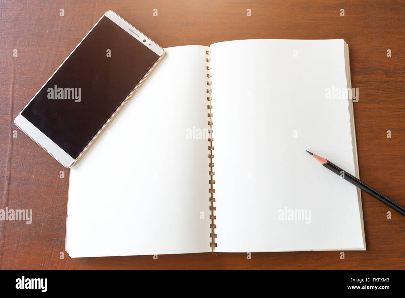 Leere Notiz Buch mit Bleistift und Smartphone auf Holztisch Hintergrund Konzept und Idee zum Schreiben Sie hier Ihren Text. Stockfoto