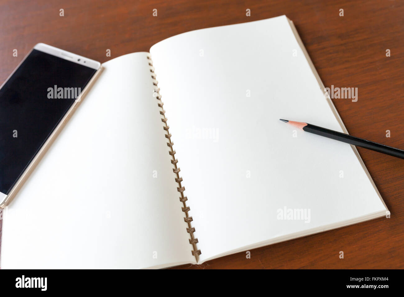 Leere Notiz Buch mit Bleistift und Smartphone auf Holztisch Hintergrund Konzept und Idee zum Schreiben Sie hier Ihren Text. Stockfoto