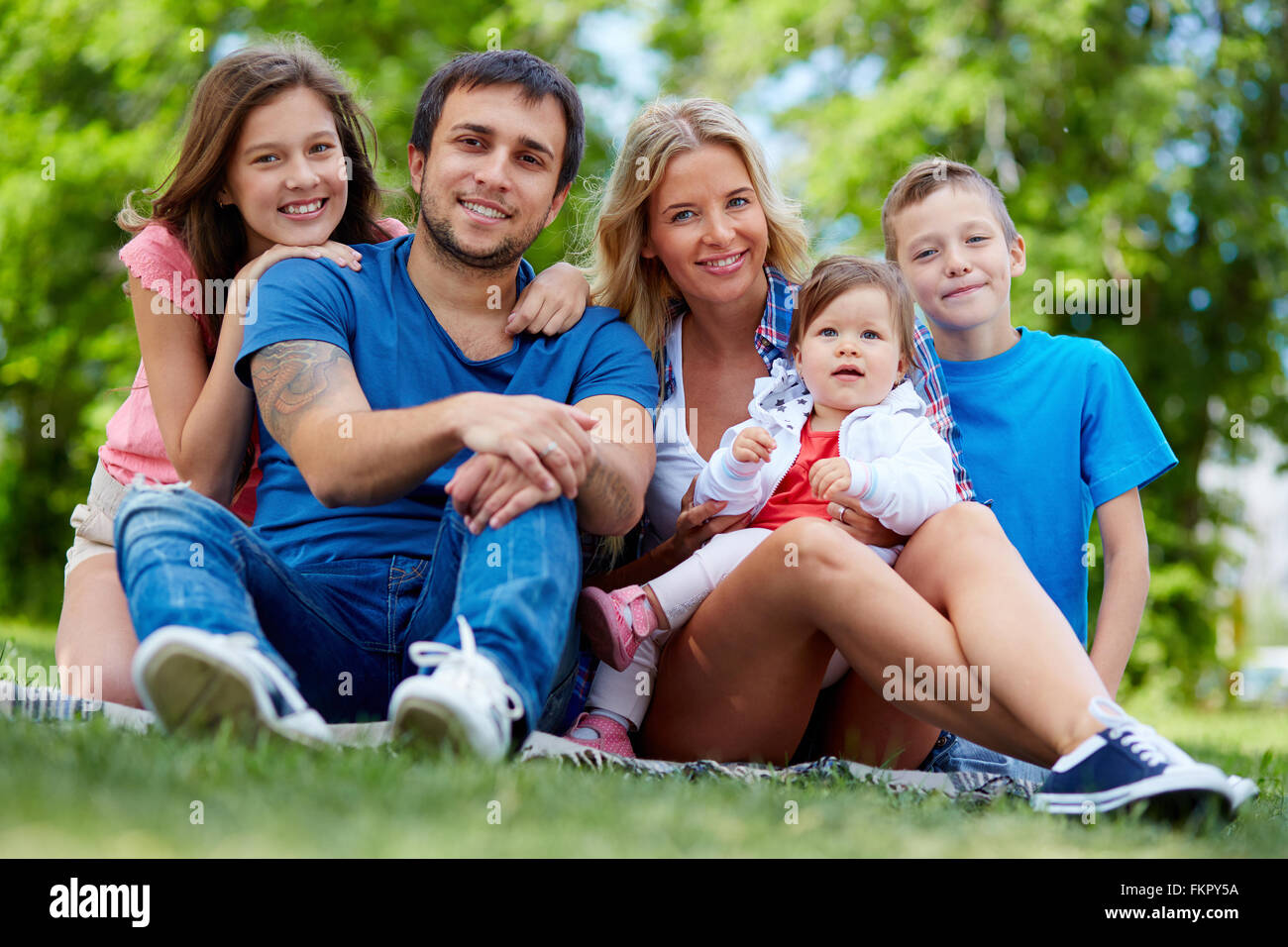 Porträt einer glücklichen Familie von fünf sitzen auf Rasen Stockfoto