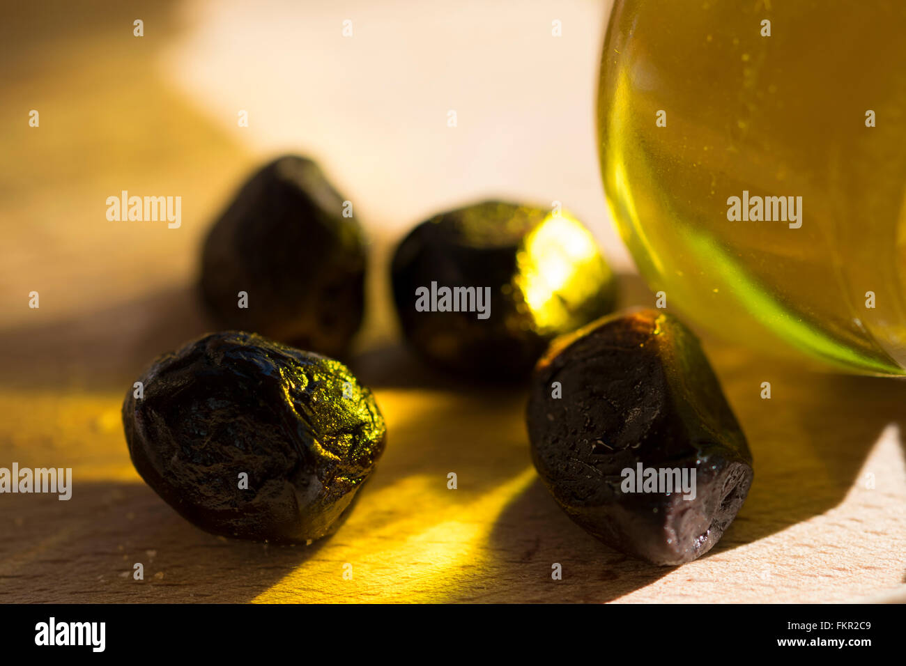 Olivenölflasche mit einigen Oliven Stockfoto