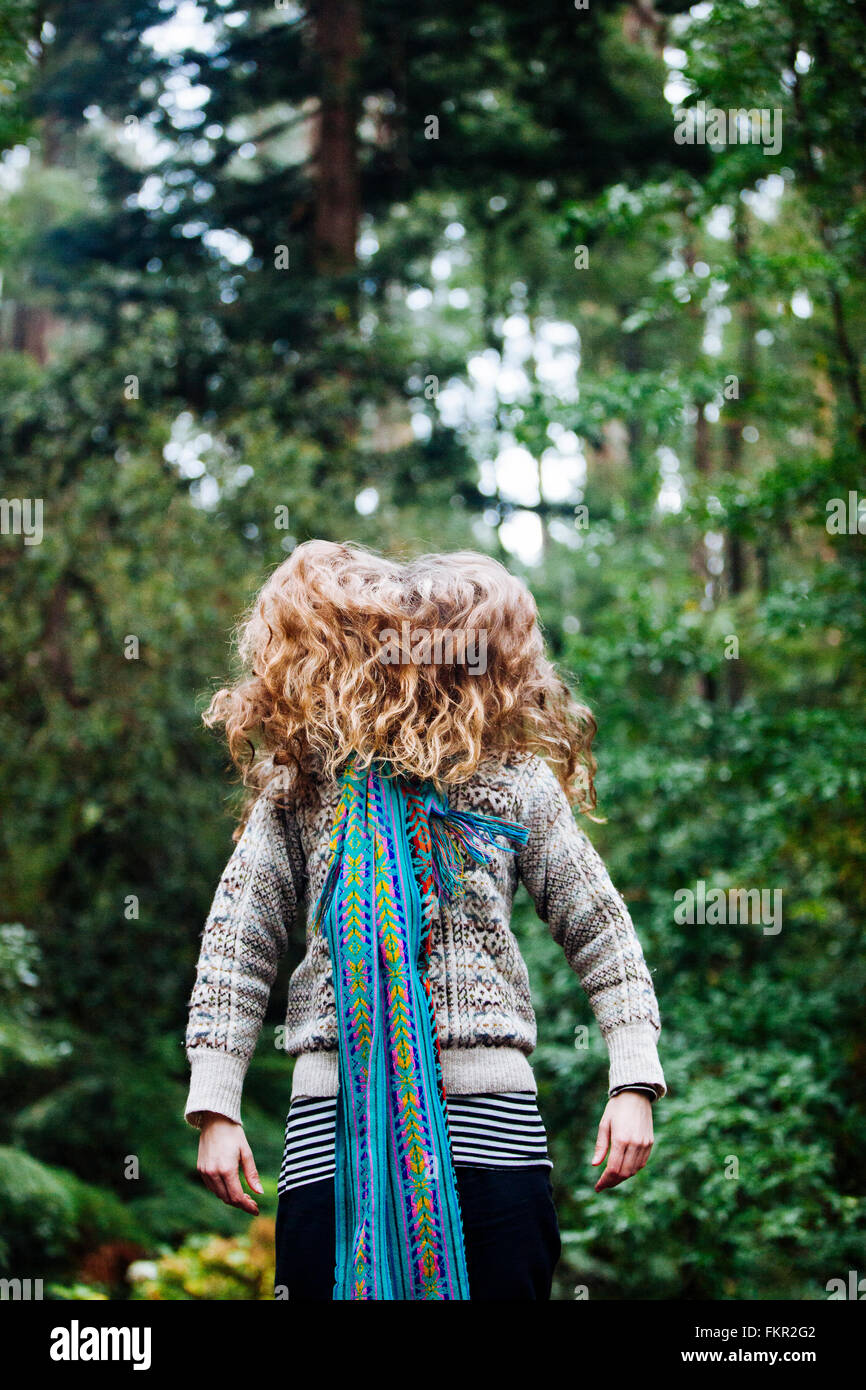 Kaukasische Frau wirft Haar im Wald Stockfoto
