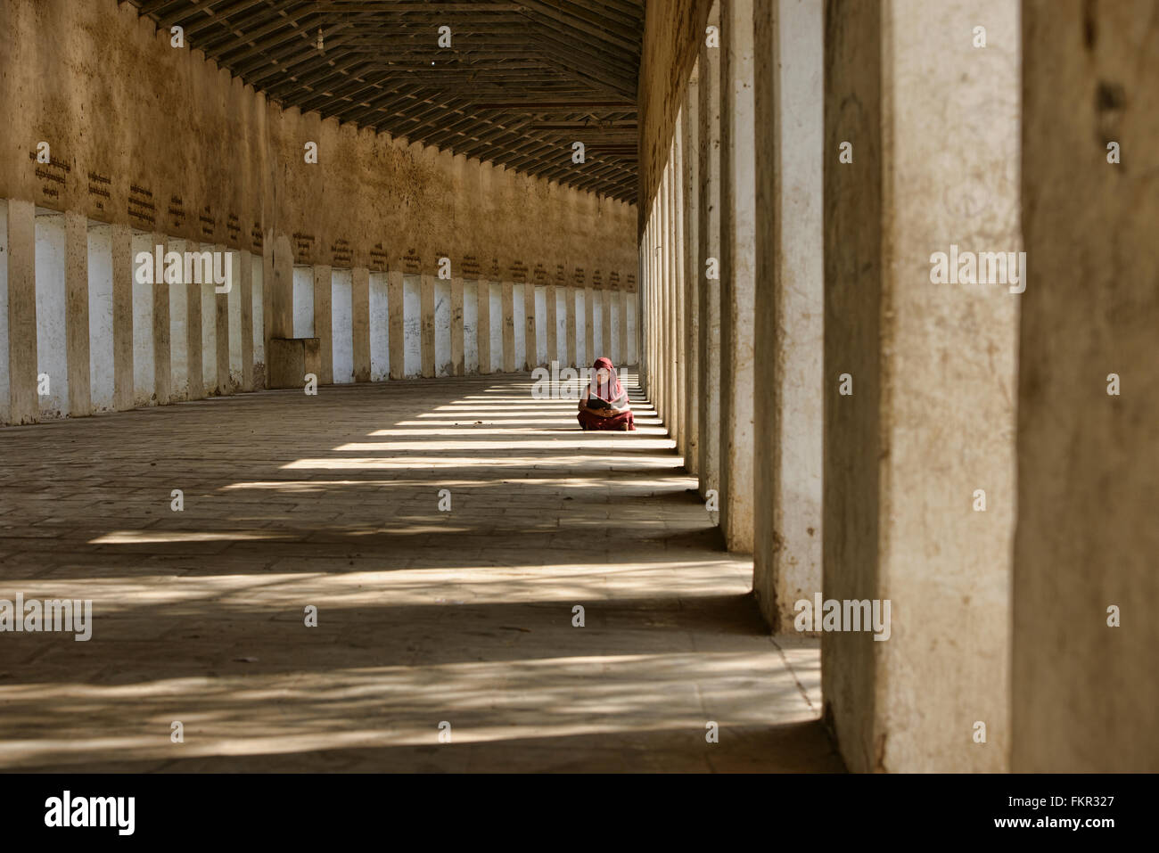 Ein junger Mönch lesen am Eingang zur Shwezagon Pagode in Bagan, Myanmar Stockfoto