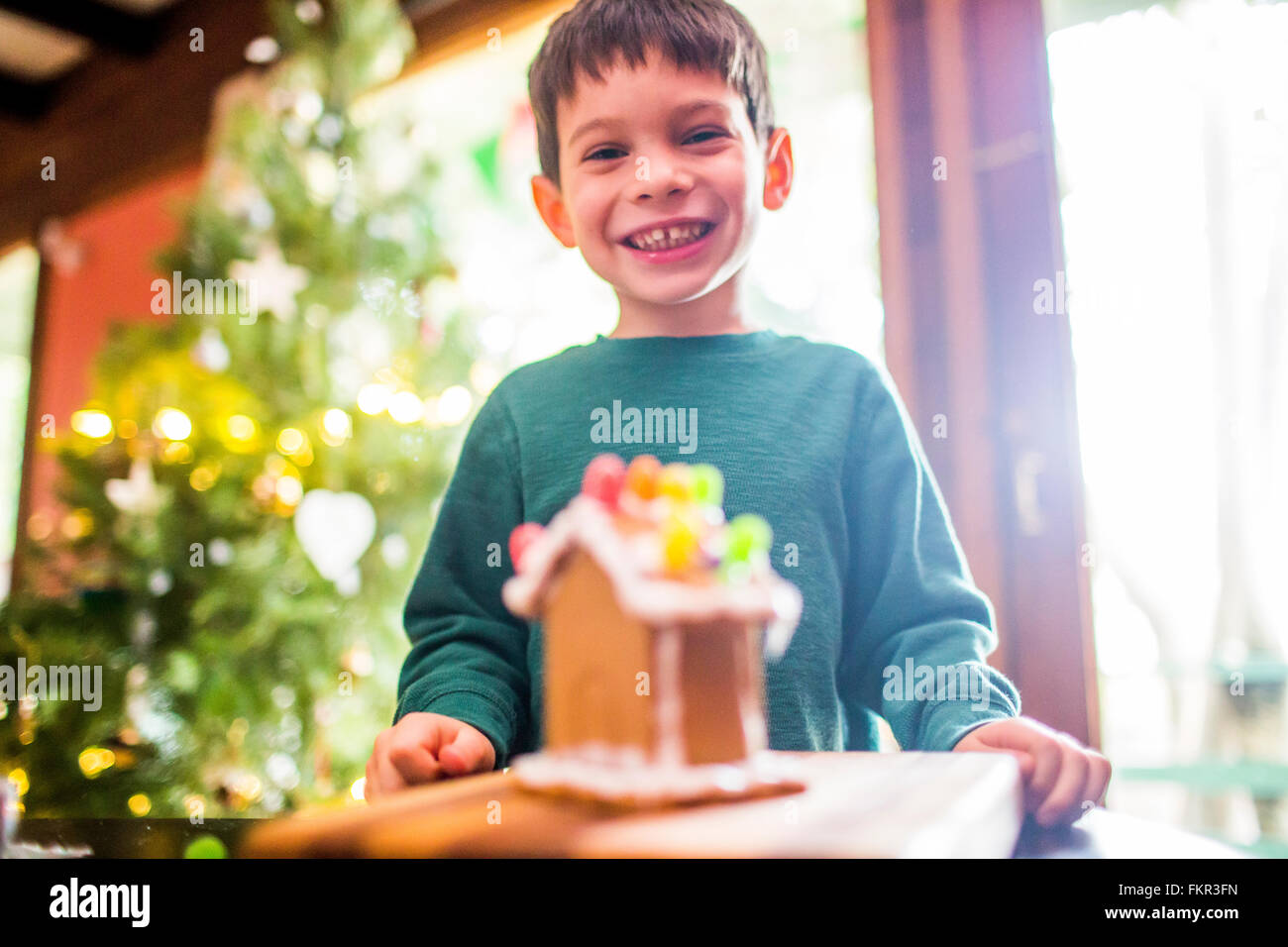 Gemischte Rassen junge lächelnd mit Lebkuchen-Haus Stockfoto
