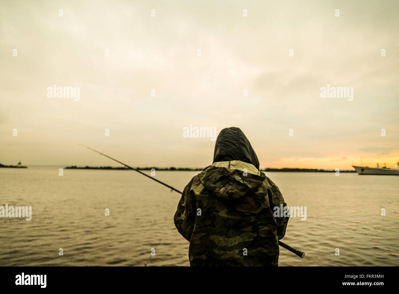 Kaukasischen Mann in abgelegenen See angeln Stockfoto