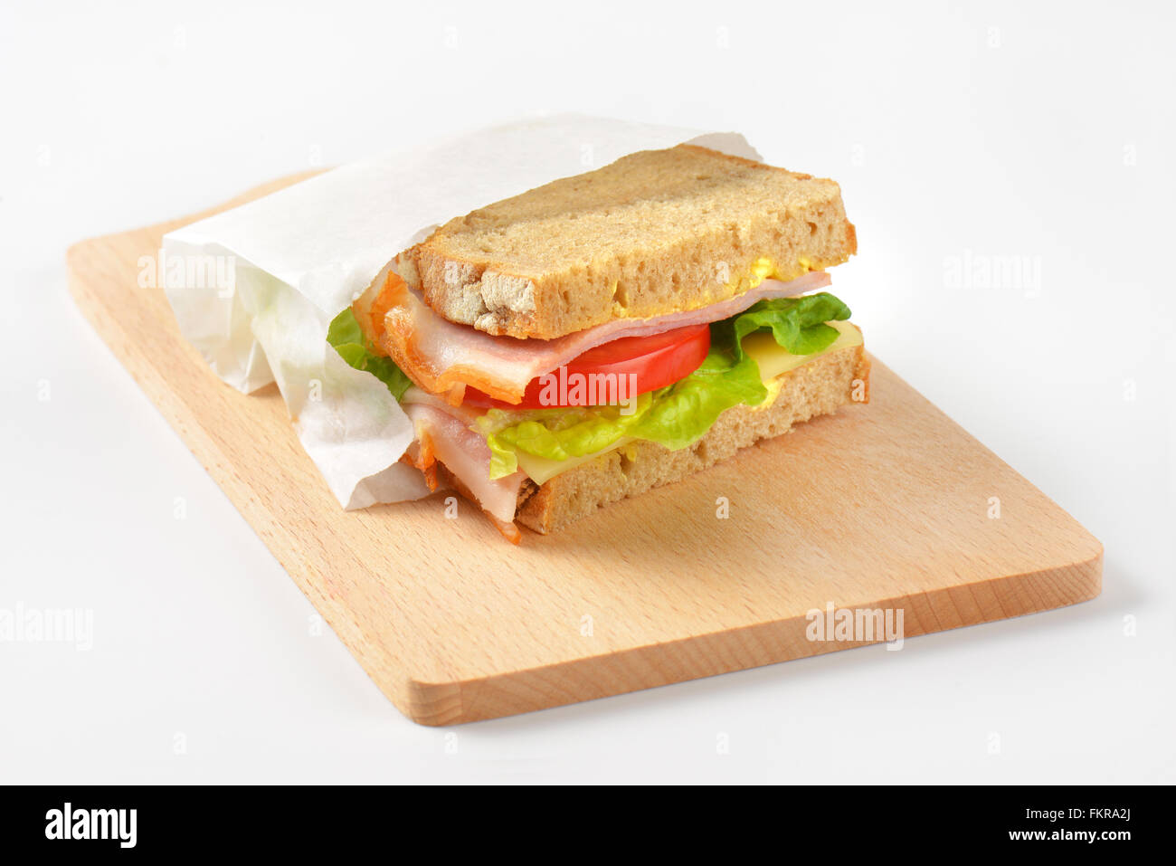 frisches Sandwich mit Schinken, Käse und Gemüse in Papiertüte Stockfoto