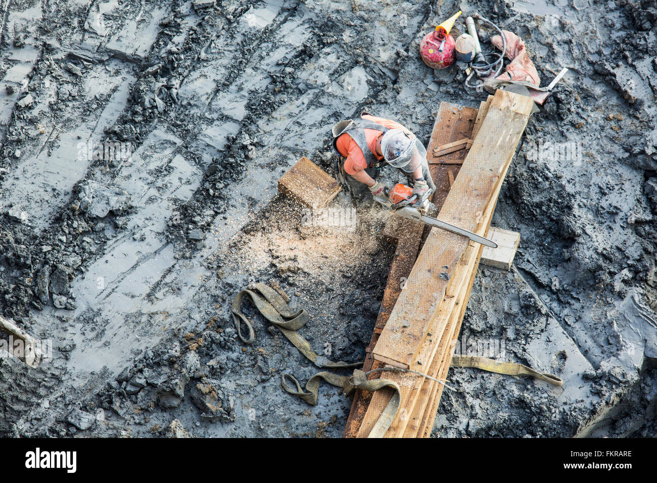 Kaukasische Arbeiter Sägen von Holz auf Baustelle Stockfoto