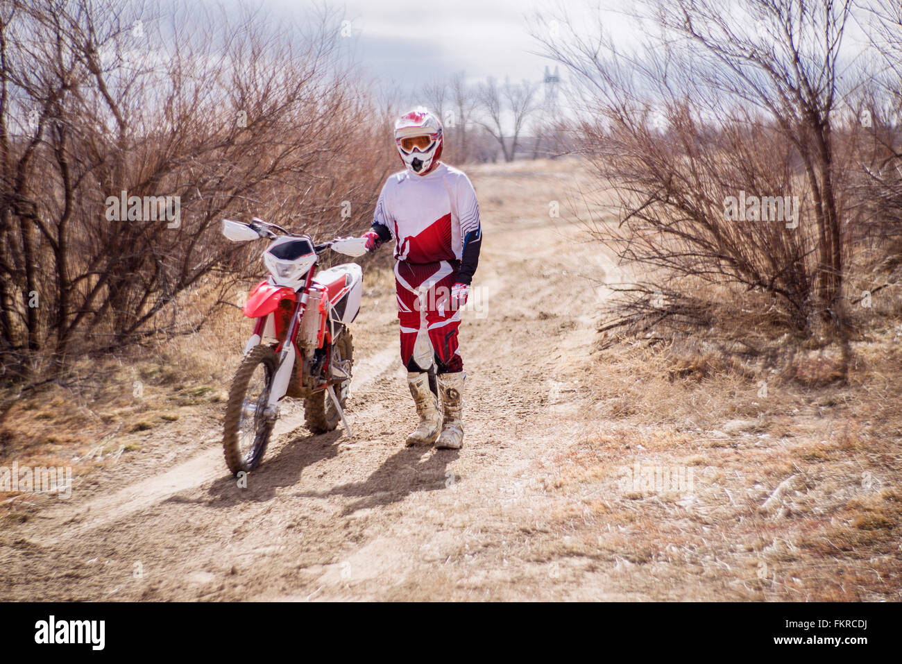 Dirt Bike Fahrer stehend mit Motorrad im ländlichen Bereich Stockfoto