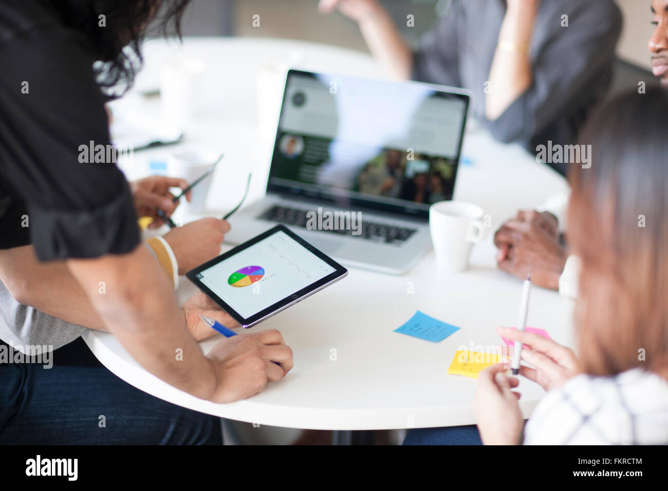 Geschäftsleute, die mit digital-Tablette im Büro treffen Stockfoto