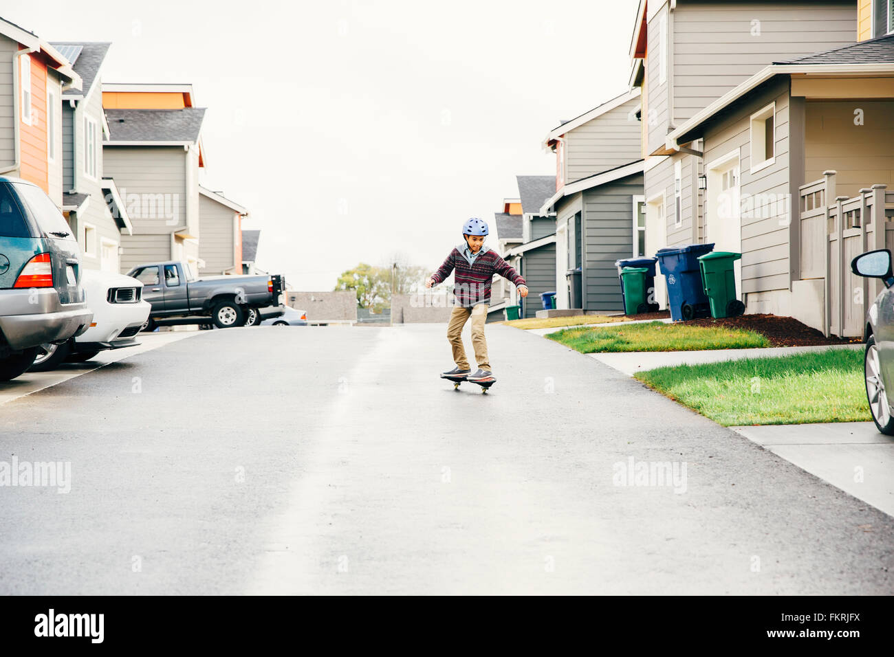 Gemischte Rassen junge fahren Skateboard auf Straße Stockfoto