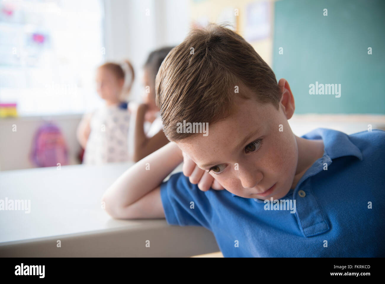 Traurig Student stützte sich auf Schreibtisch Stockfoto