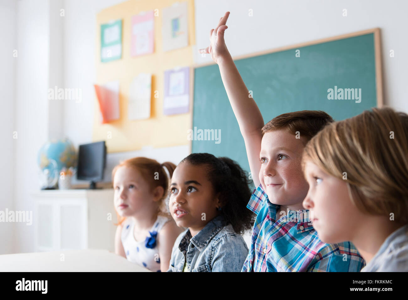Student, hob die Hand im Klassenzimmer Stockfoto