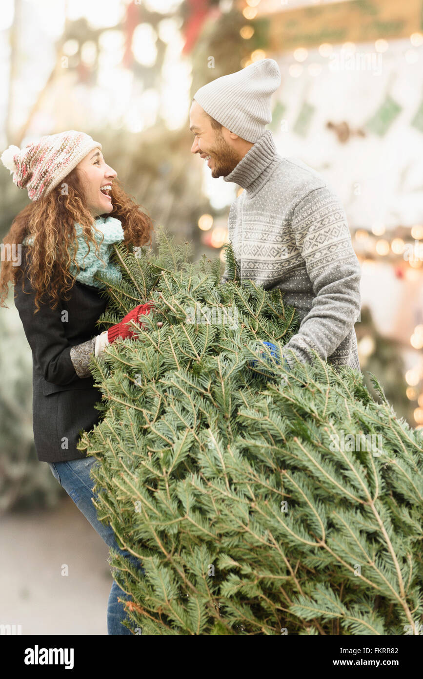 Paar schleppen Baum auf Christmas Tree farm Stockfoto