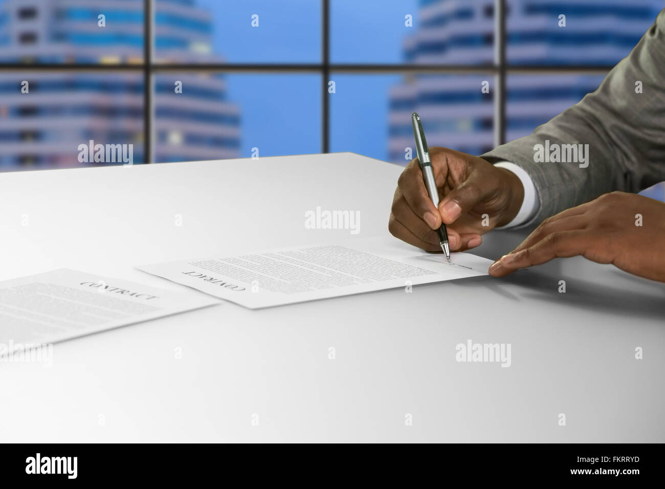Afroamerikanischen unterzeichnet Dokument im Büro. Stockfoto