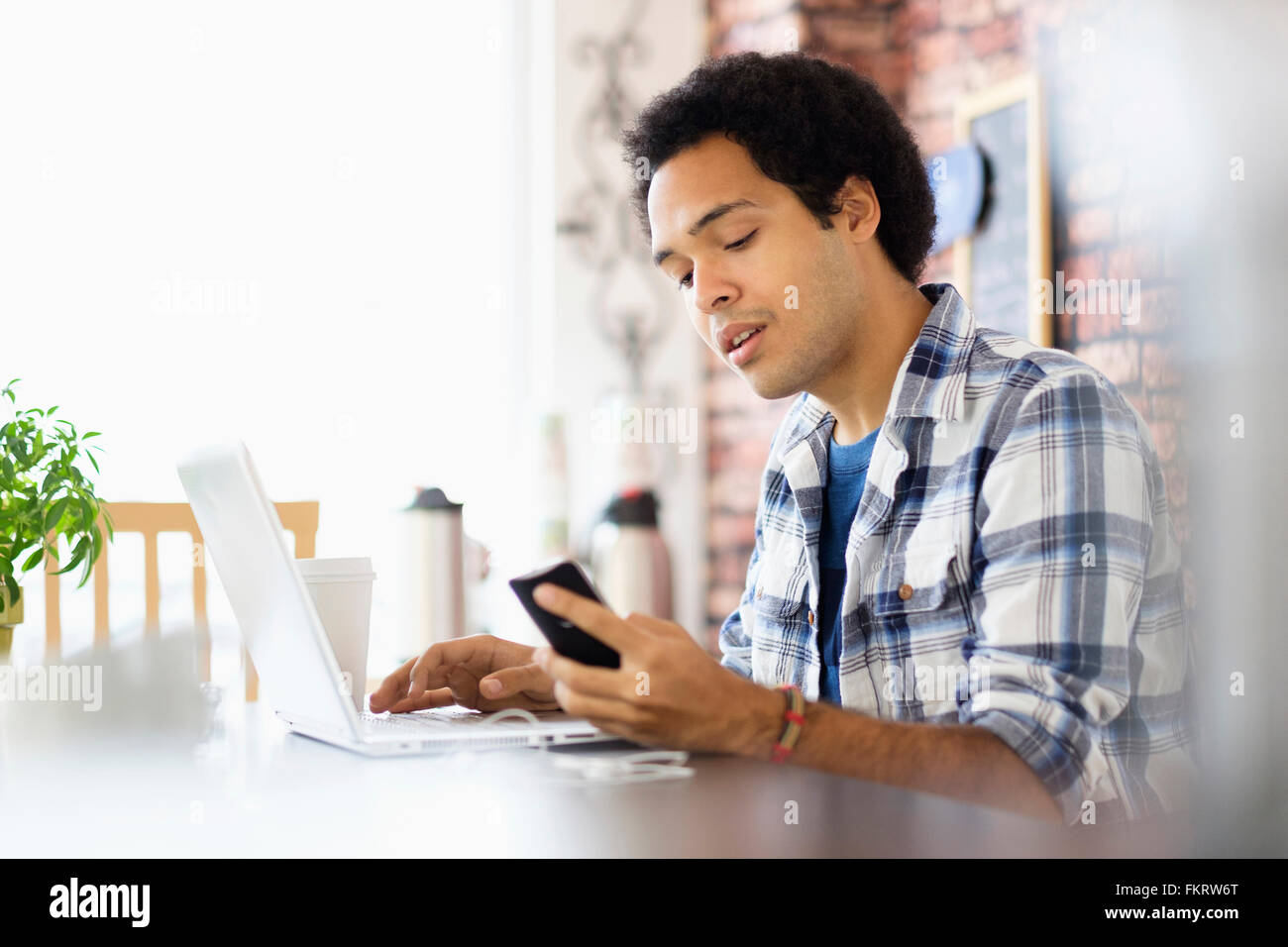 Gemischte Rassen Mann Multitasking in Coffee-shop Stockfoto