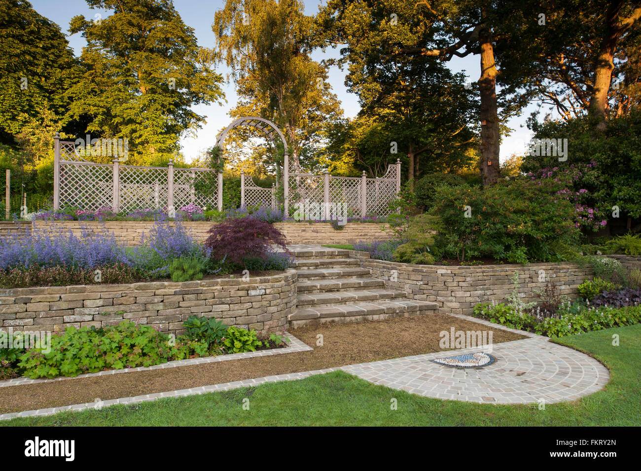 Pflasterarbeiten, Pflanzen, Mauer, Stufen, Rankgitter Bogen und Zaun - gestaltete, gepflegten Garten, Burley in Wharfedale, Yorkshire, England. Stockfoto