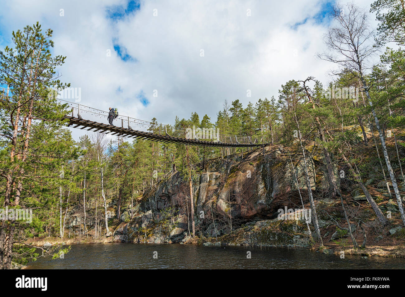 Trekker Überquerung einer Hängebrücke in Repovesi Nationalpark, Finnland. Stockfoto