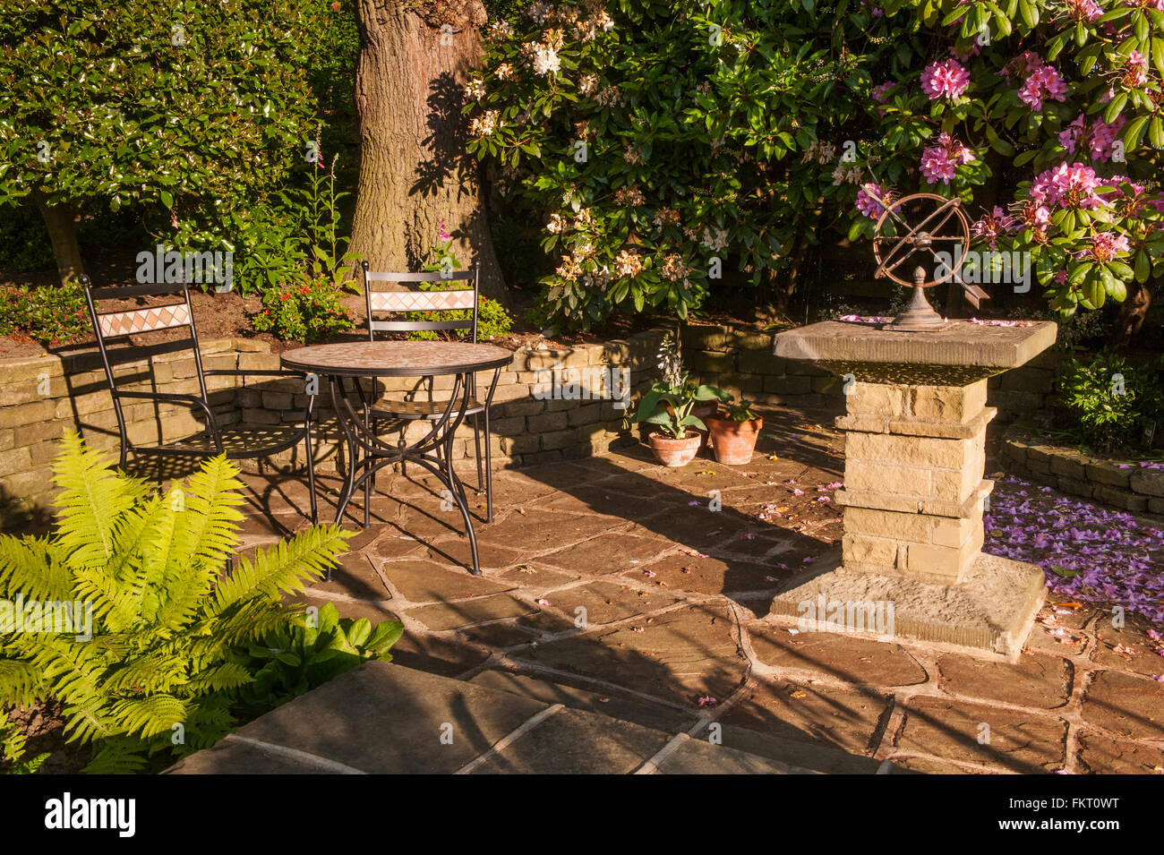 Tisch, Stühle und steinernen Sonnenuhr auf Terrasse im Sommer-Sonne - schönen, traditionellen, gepflegten Garten, Burley in Wharfedale, Yorkshire, England. Stockfoto