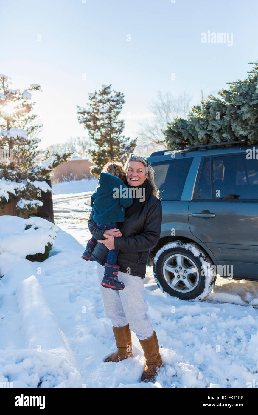 Kaukasische Mutter Holding Sohn im Schnee Stockfoto