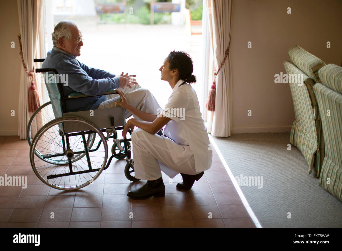 Krankenschwester im Gespräch mit Patienten im Rollstuhl Stockfoto