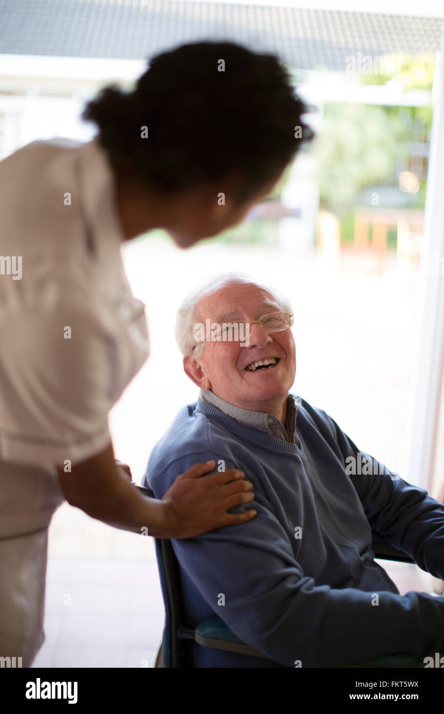 Arzt im Gespräch mit Patienten im Rollstuhl Stockfoto