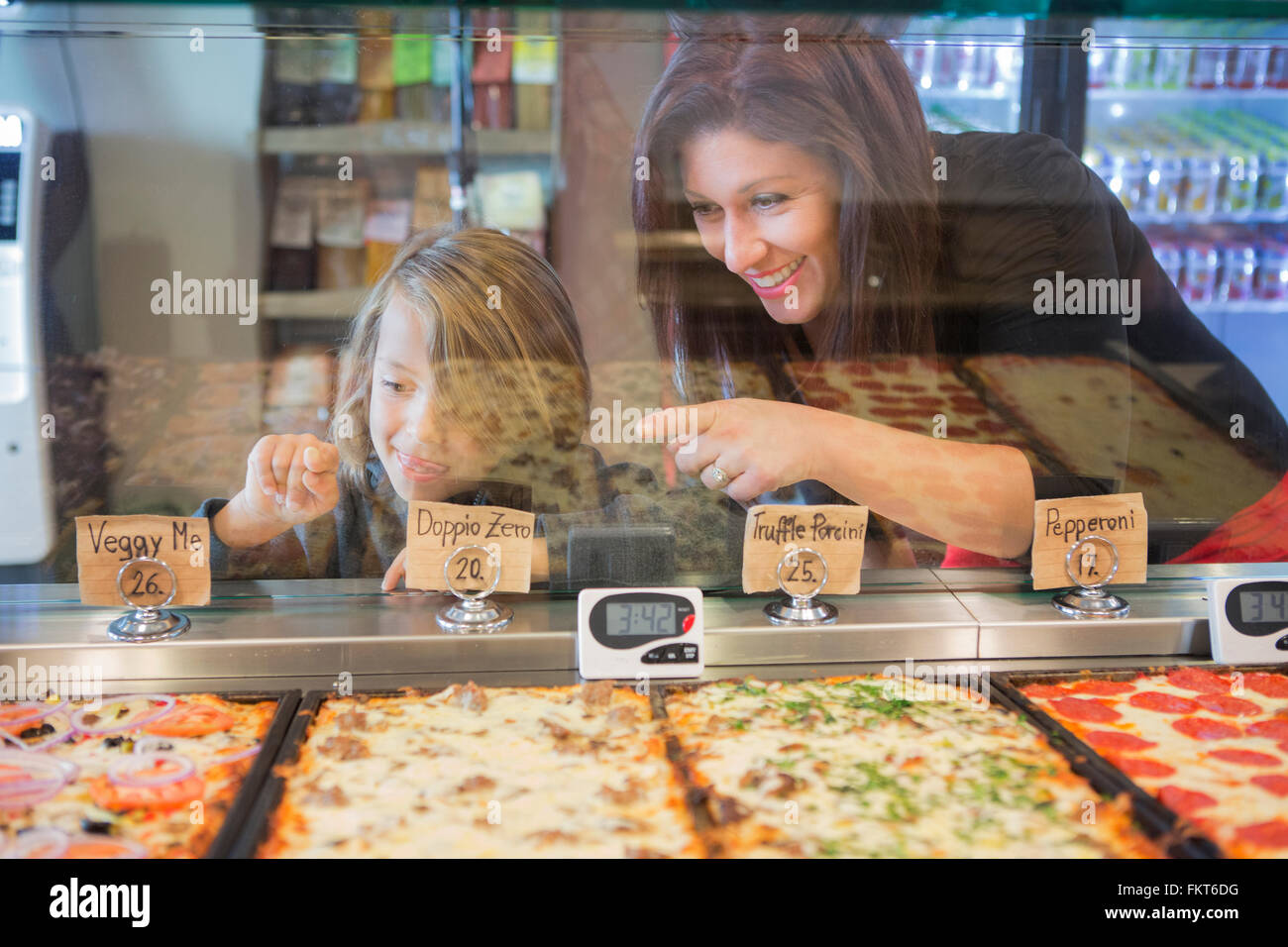 Mutter und Tochter, die Wahl von Pizza im café Stockfoto