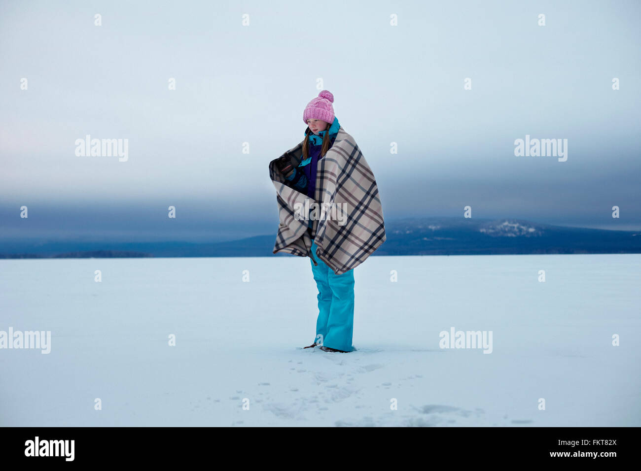 Kaukasische Teenager-Mädchen in Decke in Schnee gehüllt Stockfoto