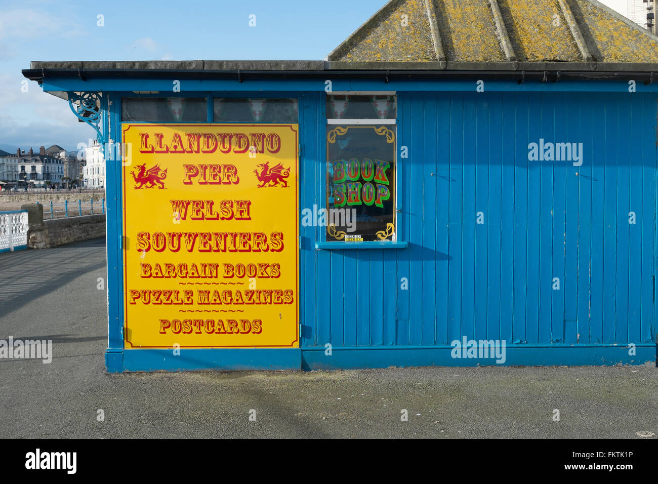 Rote und gelbe Ladenschild auf einem blau bemalte hölzerne Gebäude auf Llandudno Pier Llandudno North Wales Großbritannien Vereinigtes Königreich Stockfoto