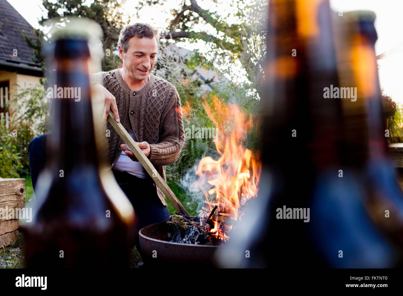 Reifer Mann mit Stock, Feuerstelle stecken Stockfoto