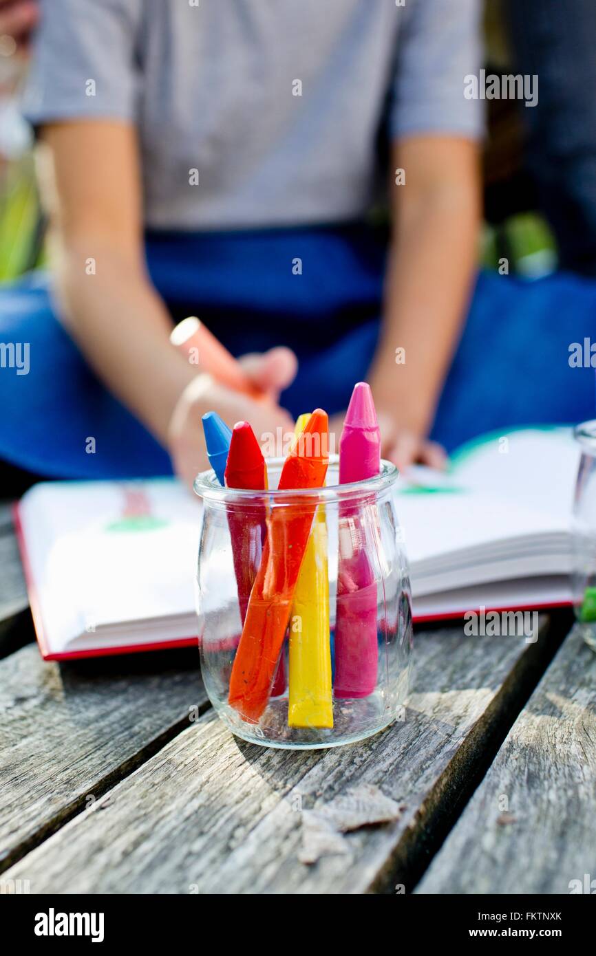 Glas-Buntstifte hautnah mit Mädchen im Hintergrund Stockfoto