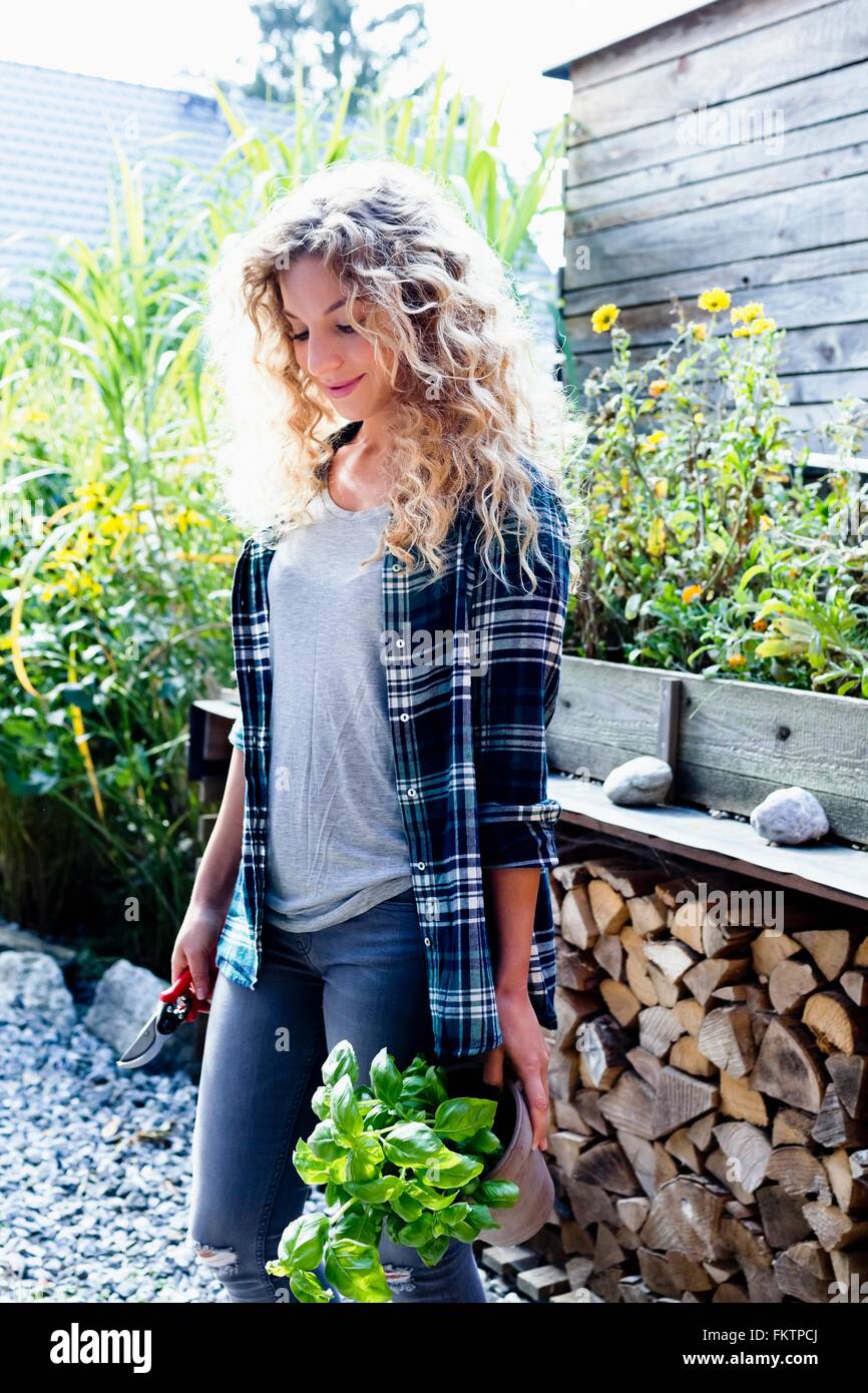 Junge Frau mit lockigen blonden Haaren im Garten, portrait Stockfoto