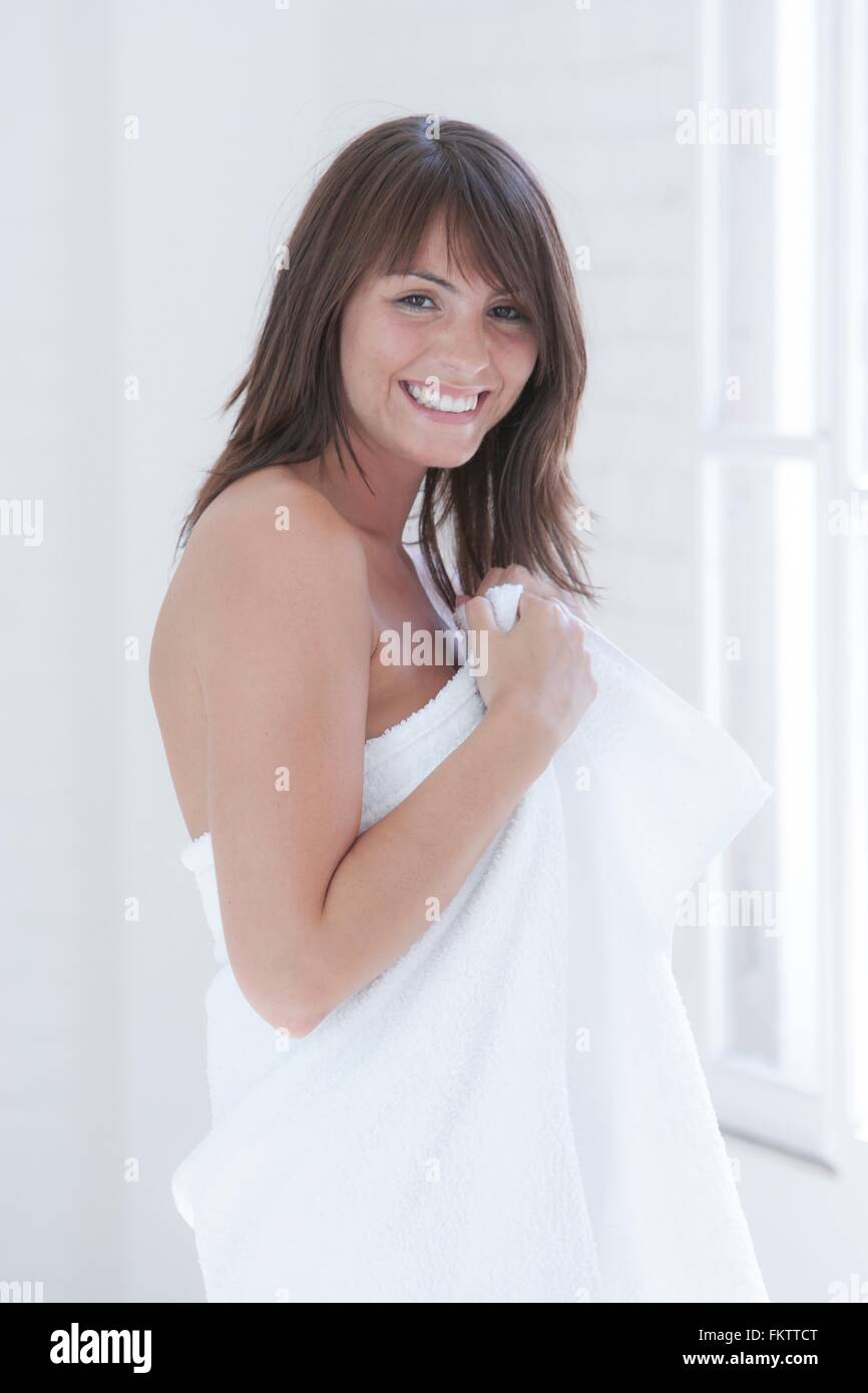 Porträt der schönen jungen Frau, die in ein Handtuch gewickelt Stockfoto