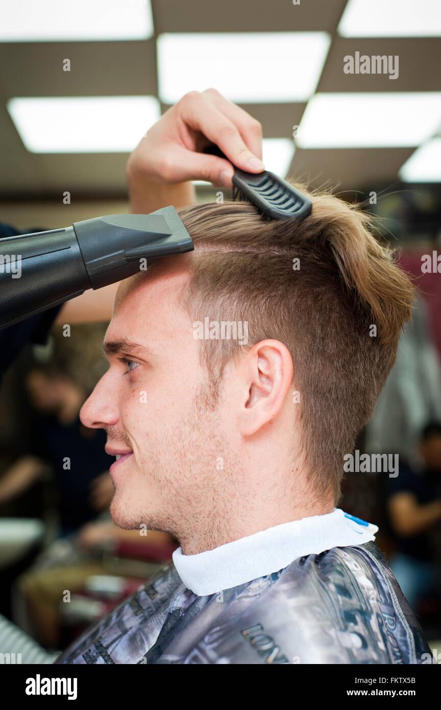 Seitenansicht des Jünglings im Barbershop haben Haare Schlag getrocknet Stockfoto