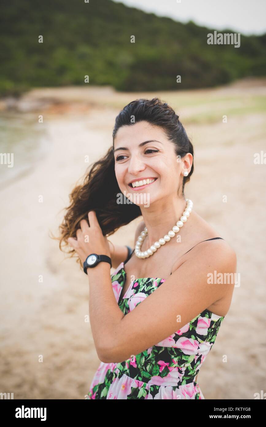 Frau am Strand, Hände in den Haaren Stockfoto