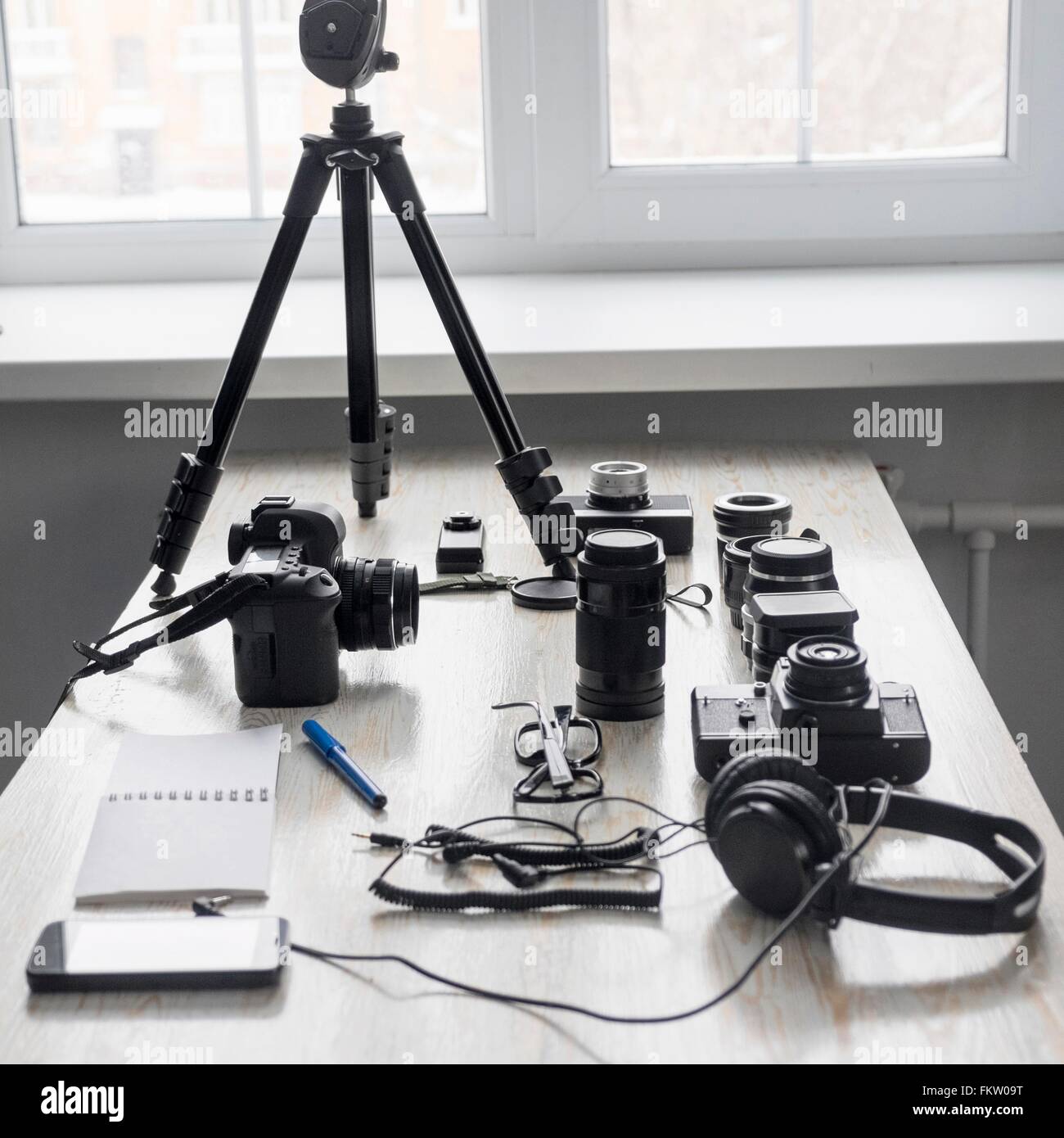 Smartphone und Fotoausrüstung auf Atelier Schreibtisch Stockfoto