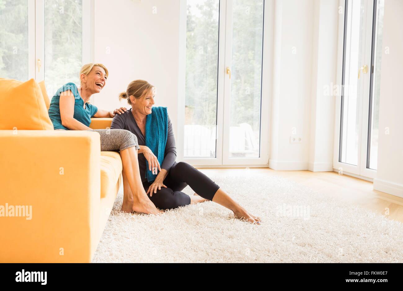 Zwei Reife Frauen, die eine Übung auf Sofa im Wohnzimmer zu brechen Stockfoto