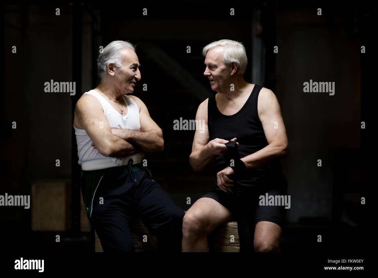 Zwei alte Männer im Chat und in dunklen Turnhalle vorbereiten Stockfoto