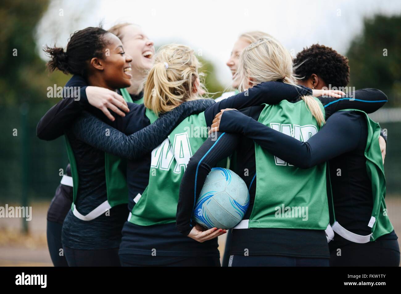 Weibliche Netball Team feiern im Huddle auf Korbball Gericht Stockfoto