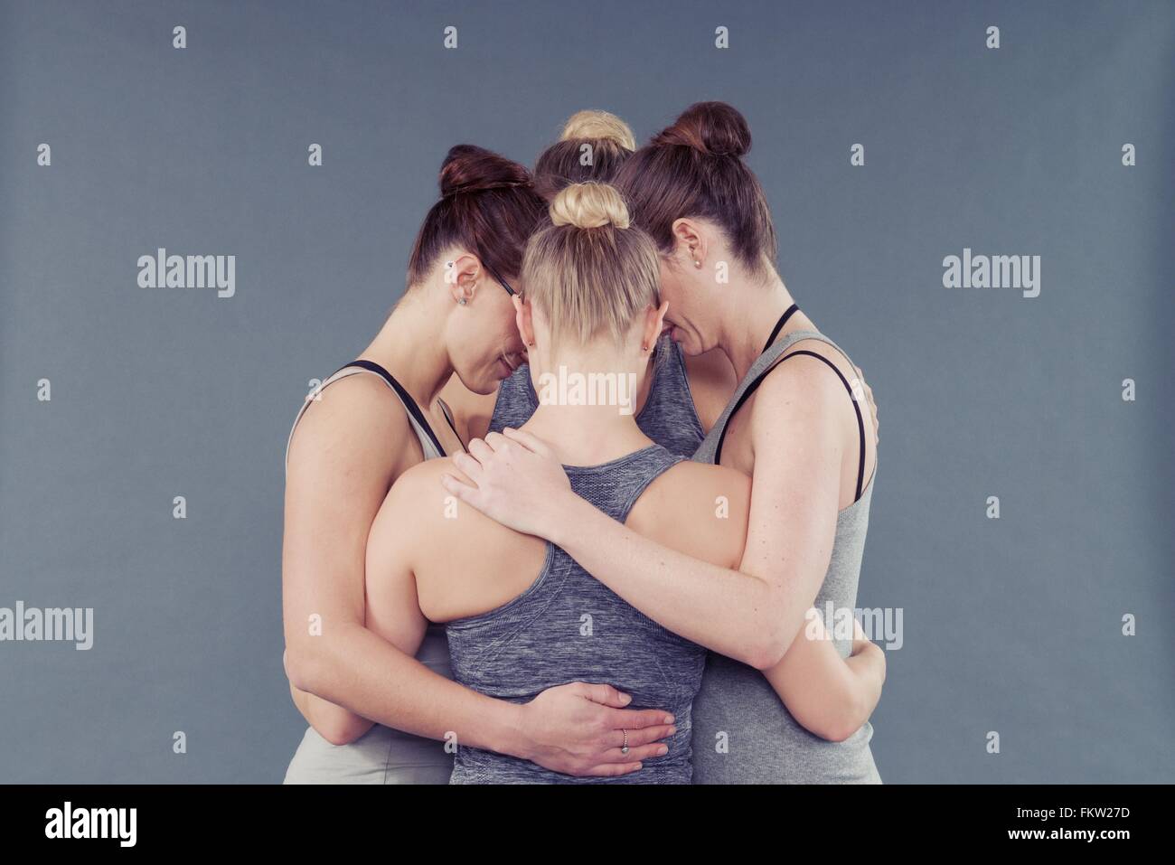 Junge Frauen in einem Huddle, grauen Hintergrund Stockfoto