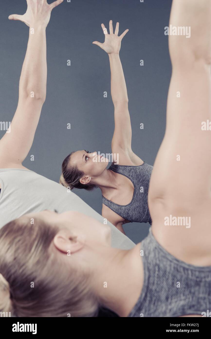 Junge Frauen praktizieren Yoga, grauen Hintergrund Stockfoto