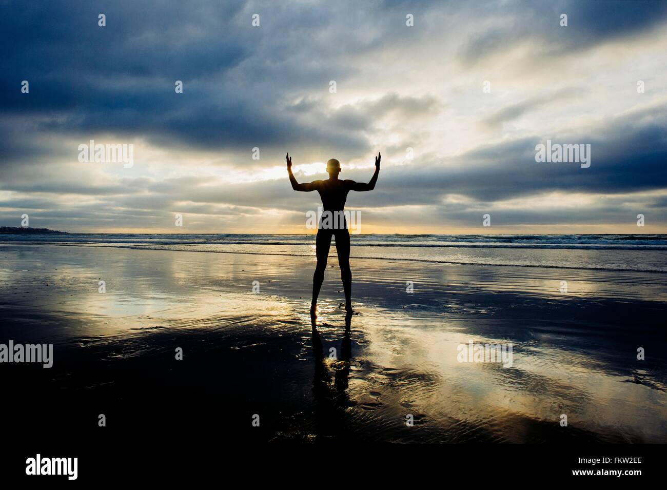 Silhouette der Person, die Arme am Strand Stockfoto