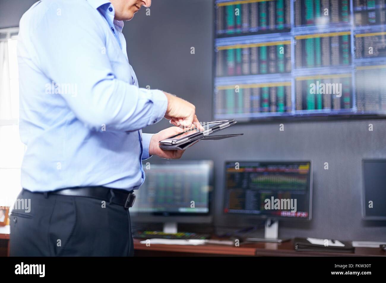 Seitenansicht der jungen Mitte Erwachsenen mans Innenfeldes im Büro mit digital-Tablette Stockfoto