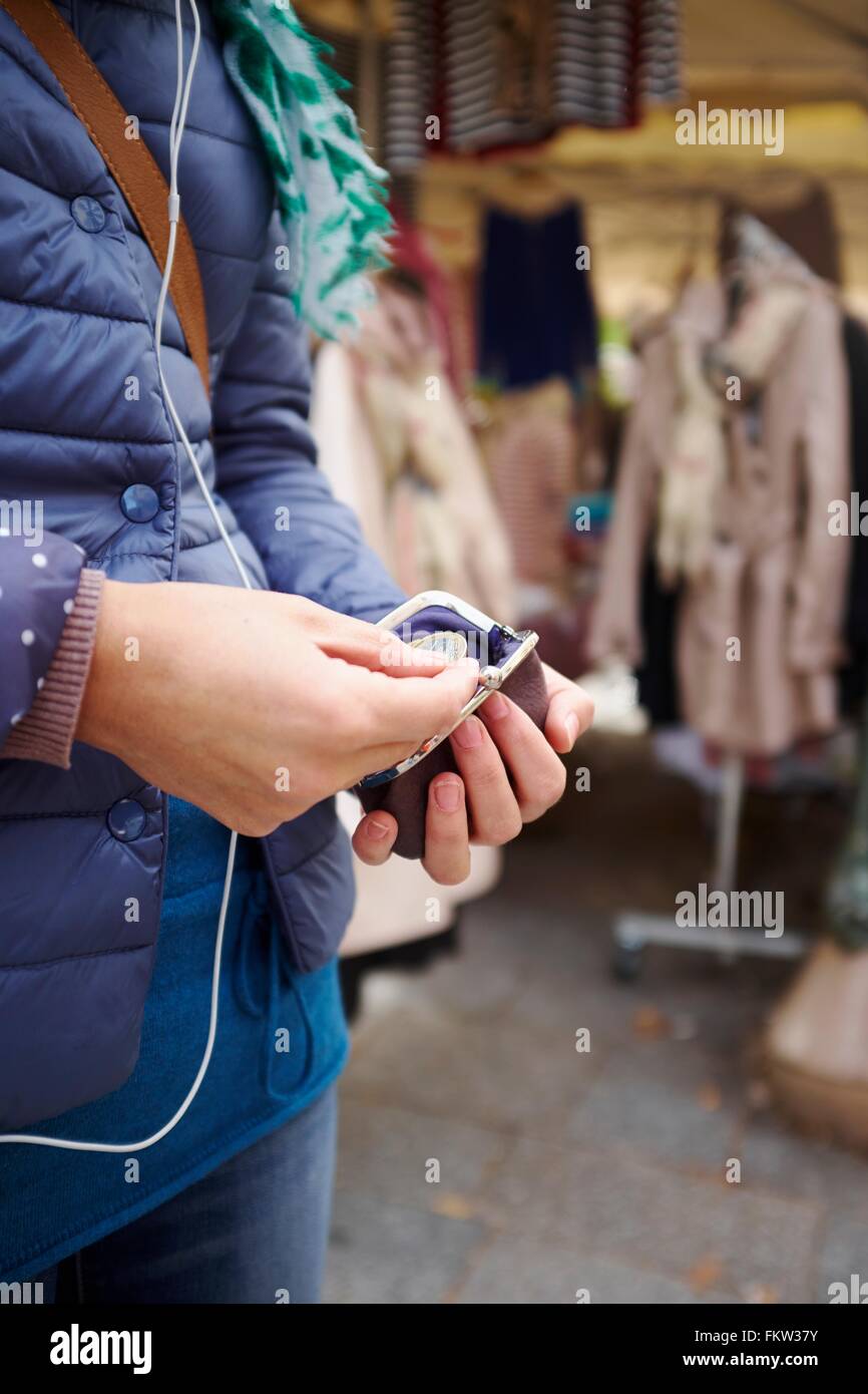 Junge Frau am Markt, wobei Geld vom Geldbeutel, Mittelteil Stockfoto