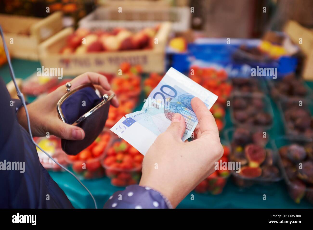 Junge Frau am Markt, wobei Geld vom Geldbeutel, Mittelteil Stockfoto