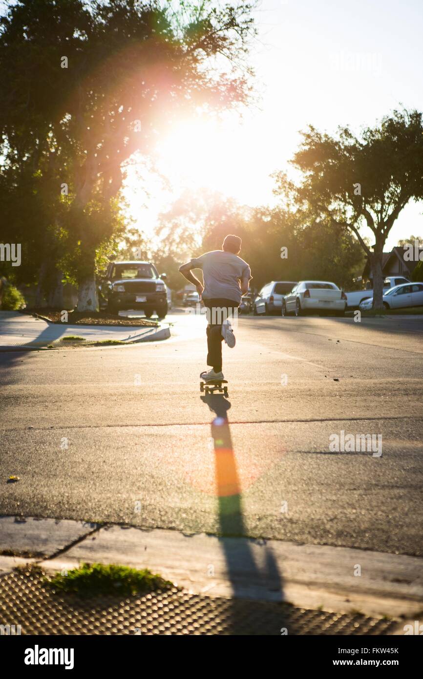 Junger Mann Skateboarden Straße, Rückansicht, Corona, Kalifornien, USA Stockfoto