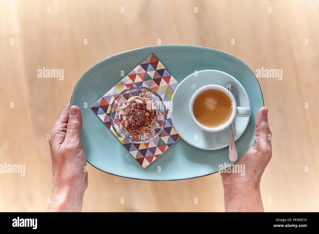 Draufsicht der weiblichen Hände halten Dessert Teller und Tasse espresso Stockfoto
