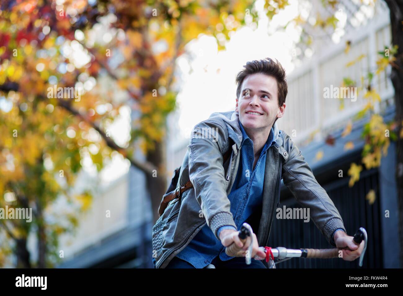 Junger Mann sucht seitwärts, während Radfahren Stockfoto
