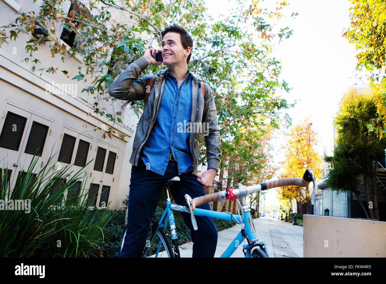 Junger Mann auf Zyklus im Chat auf smartphone Stockfoto