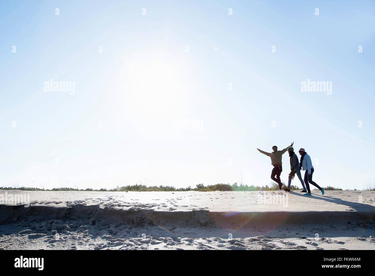 Drei Freunde Strand entlang spazieren Stockfoto