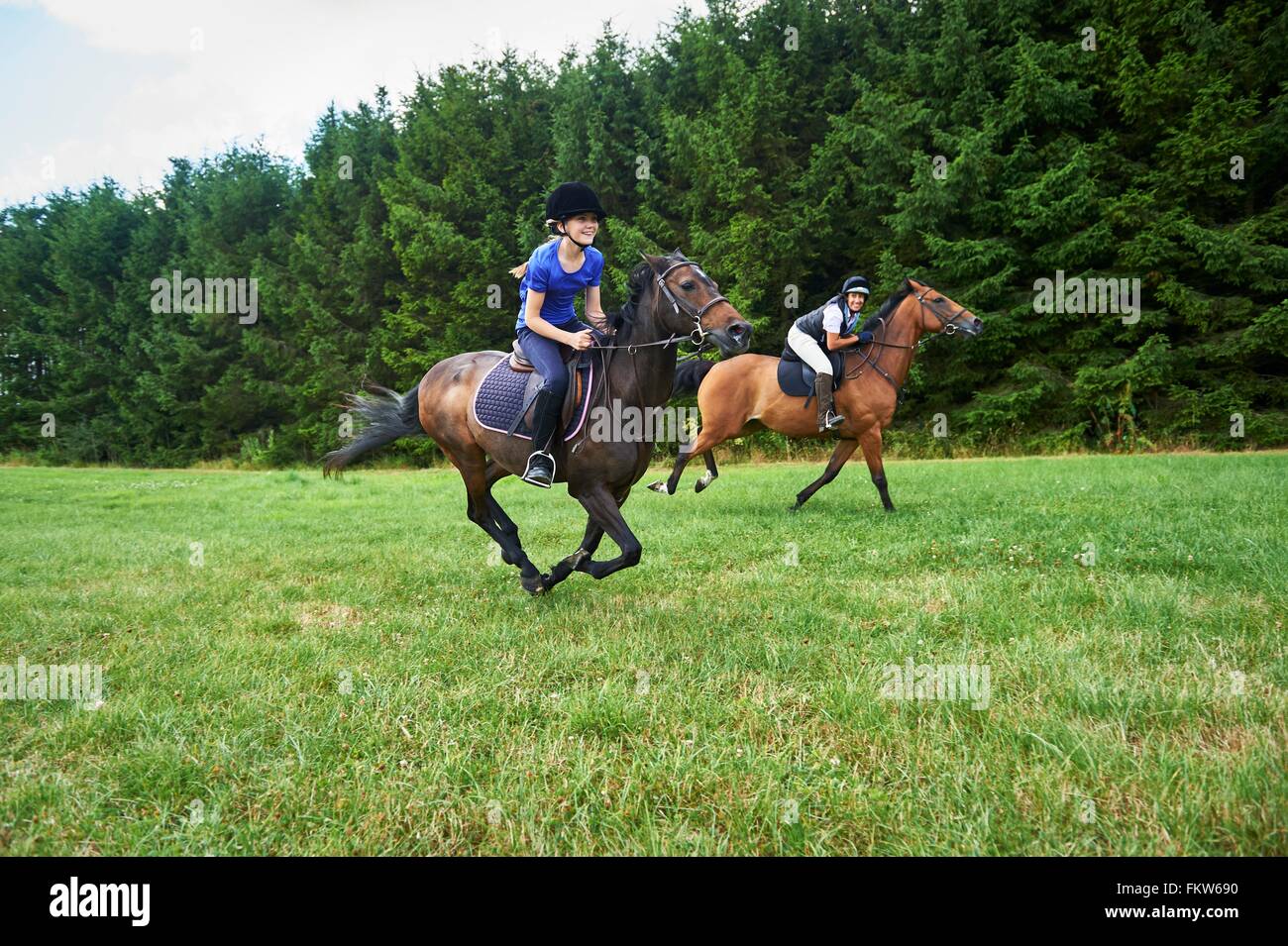 Seitenansicht der Mädchen und Reife Frau im Galopp auf dem Pferd Reiten-Hüte tragen Stockfoto