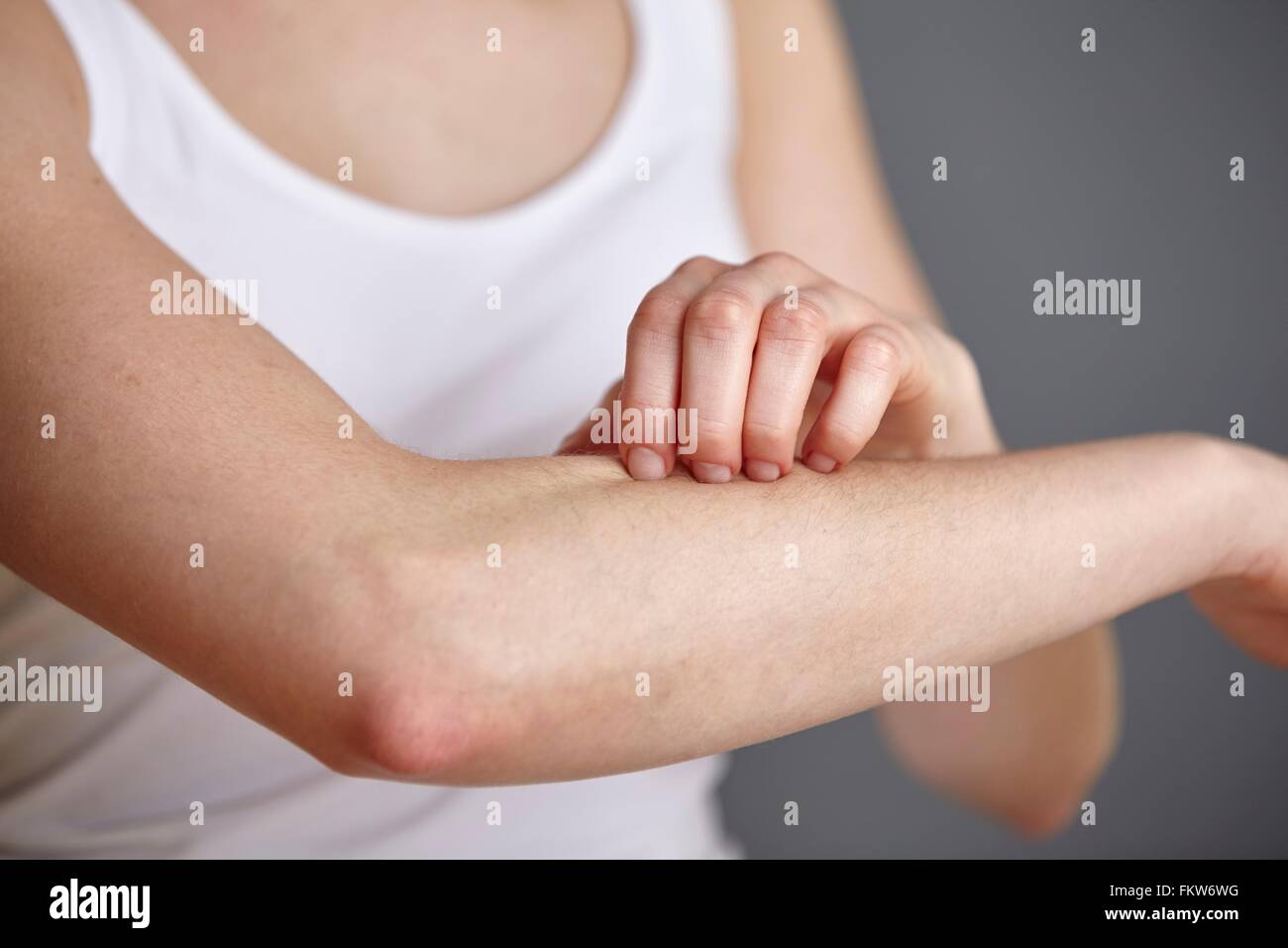 Schuss von junge Frau ihrem Unterarm mit Fingern kratzen beschnitten Stockfoto